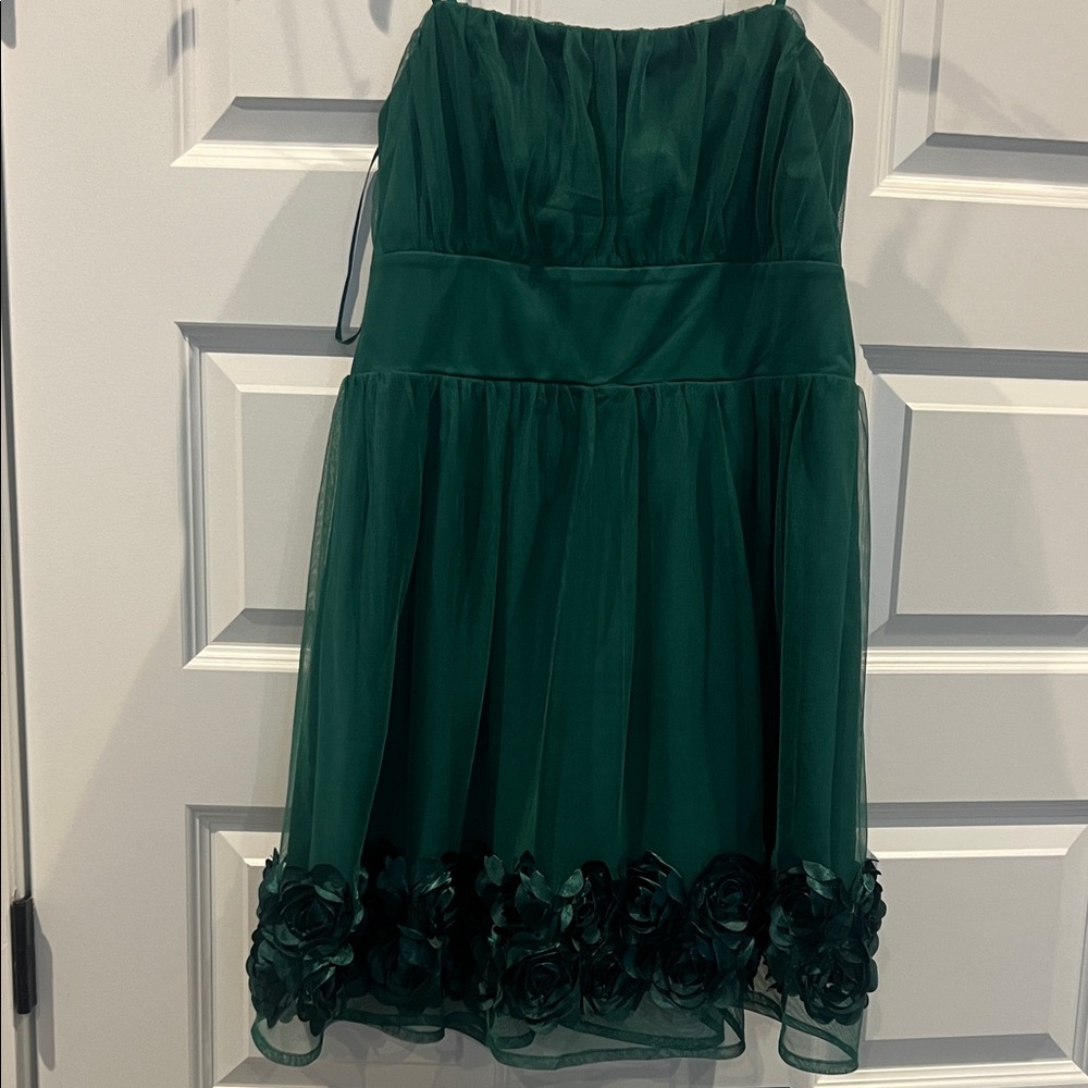 Short emerald green lace dress adorned with flowers at the bottom